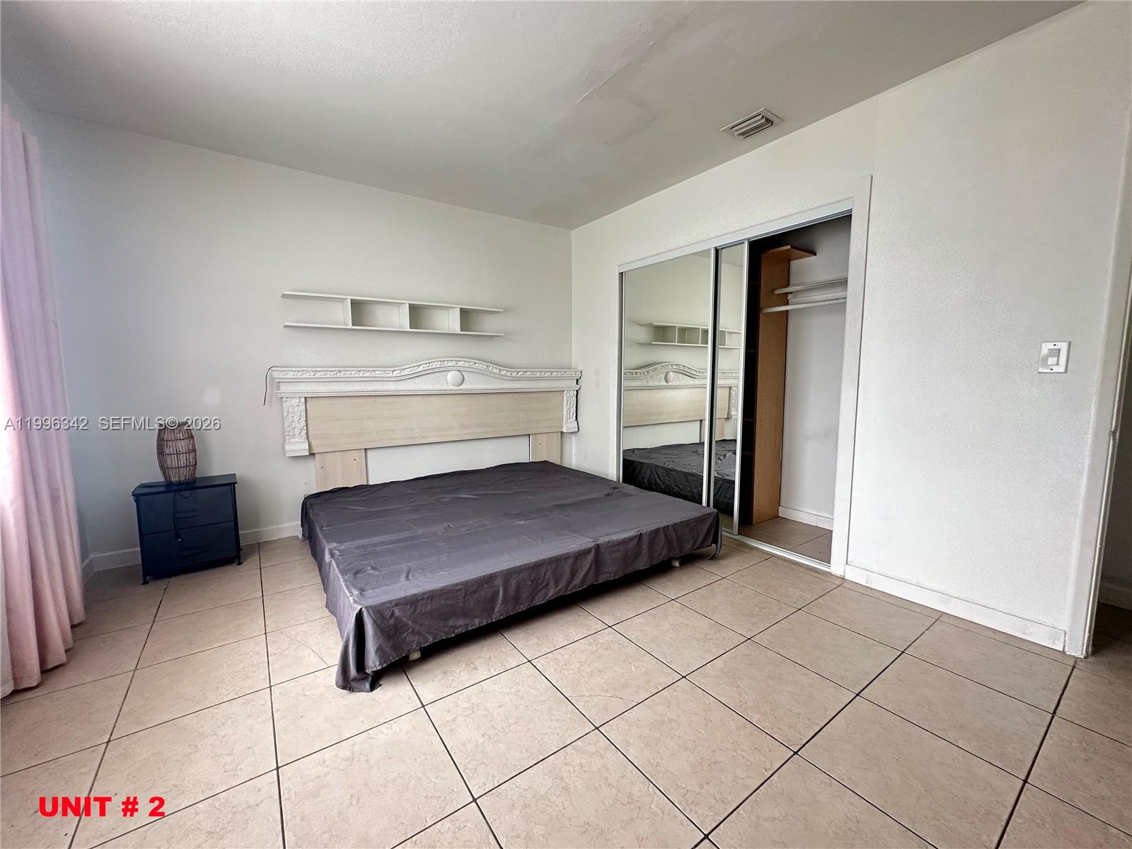 809 Northeast 2nd Street, Unit 2 Hallandale Beach, FL 33009 - Photo 6 of 8 a living room with a couch and a stove top oven