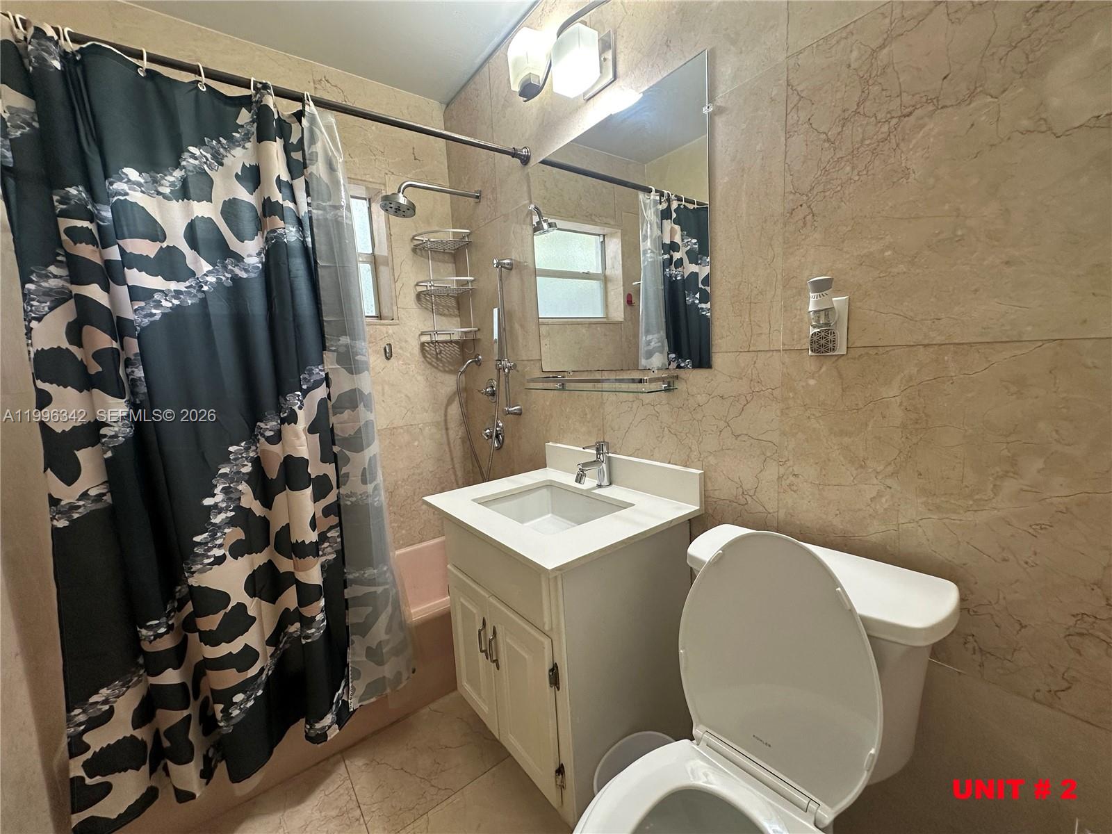 809 Northeast 2nd Street, Unit 2 Hallandale Beach, FL 33009 - Photo 7 of 8 a bathroom with a sink toilet and shower