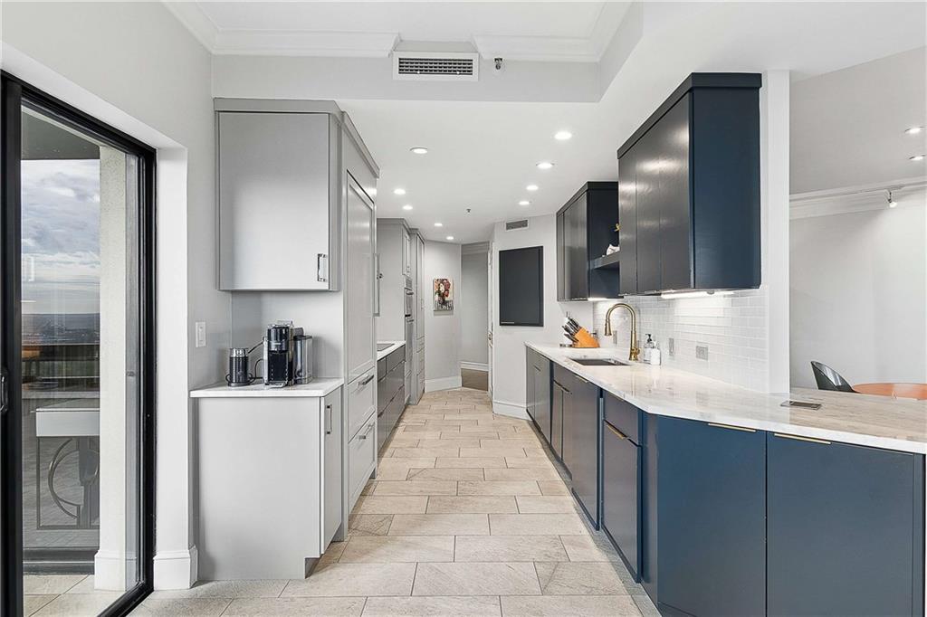 2660 Peachtree Road Northwest, Unit 34F Atlanta, GA 30305 - Photo 21 of 57 a large kitchen with stainless steel appliances lots of counter space sink and cabinets