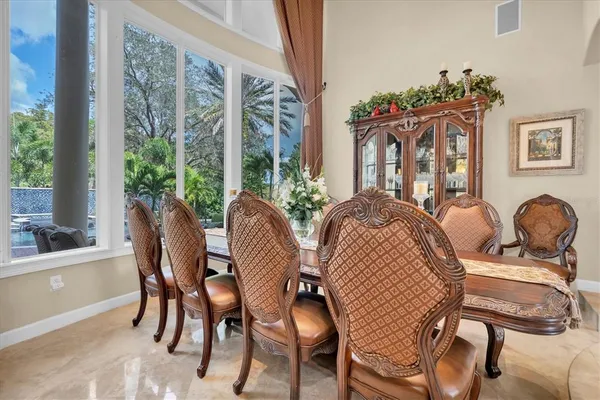 a kitchen with a table chairs refrigerator and wooden floor