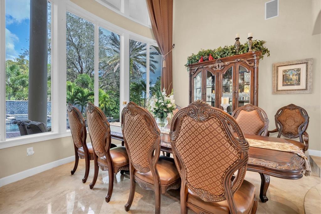 2861 Roehampton Close Tarpon Springs, FL 34688 - Photo 16 of 84 a view of a dining room with furniture wooden floor and a chandelier