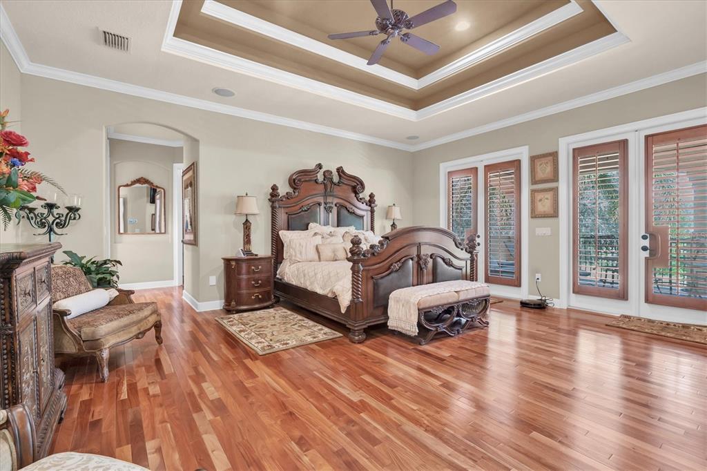 2861 Roehampton Close Tarpon Springs, FL 34688 - Photo 39 of 84 a spacious bedroom with a bed and wooden floor