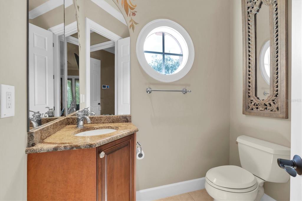2861 Roehampton Close Tarpon Springs, FL 34688 - Photo 58 of 84 a bathroom with a granite countertop toilet a sink and a mirror