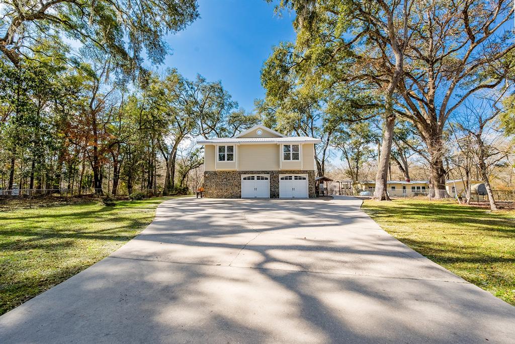 498 Southwest Manatee Terrace Fort White, FL 32038 - Photo 1 of 50 a front view of a house with a yard and large trees