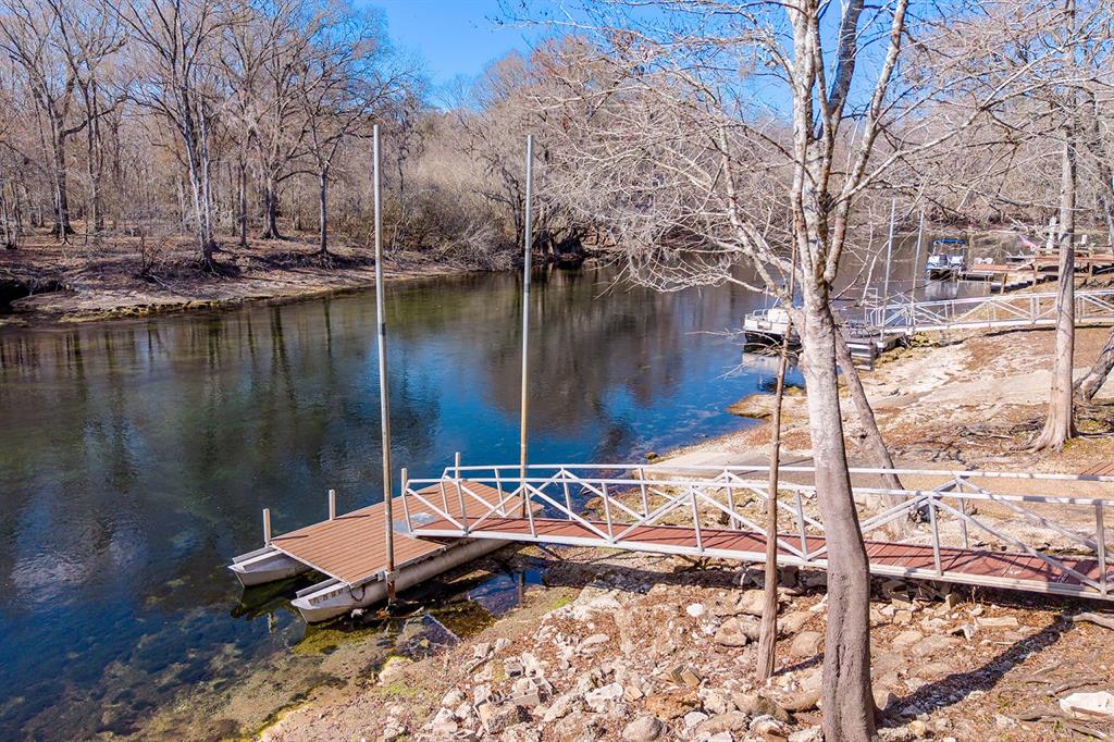 498 Southwest Manatee Terrace Fort White, FL 32038 - Photo 23 of 50 a wooden bench sitting next to a lake