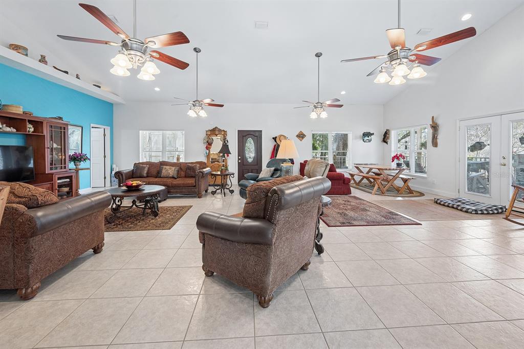 498 Southwest Manatee Terrace Fort White, FL 32038 - Photo 28 of 50 a living room with furniture a chandelier and a flat screen tv