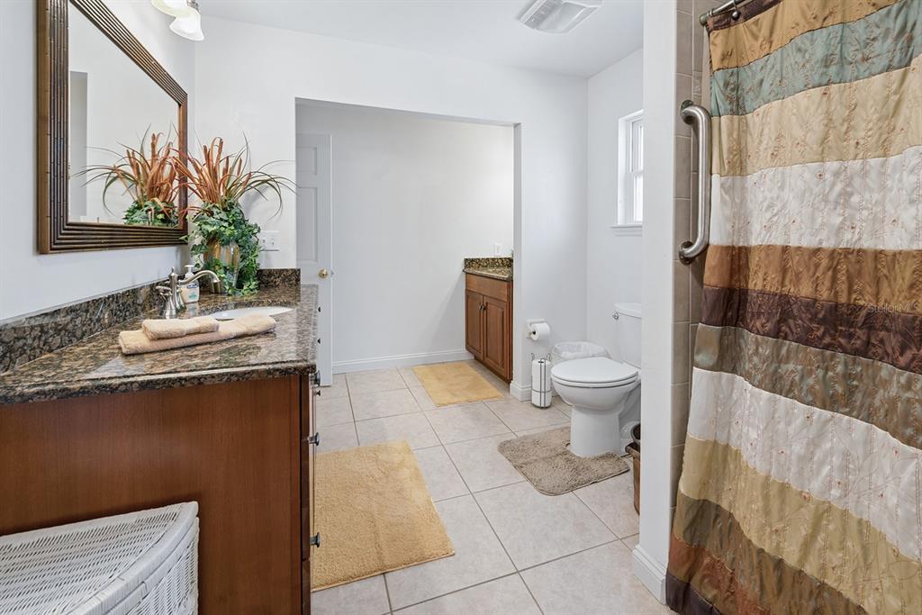 498 Southwest Manatee Terrace Fort White, FL 32038 - Photo 38 of 50 a bathroom with a granite countertop sink a toilet and shower