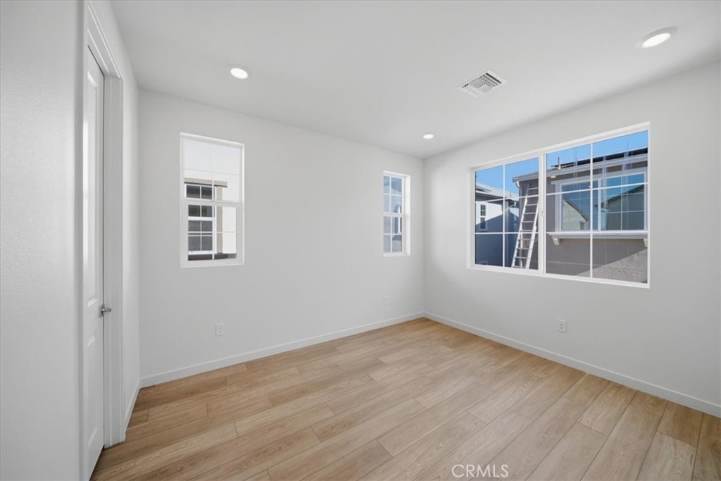 4801 Arroyo Run Moorpark, CA 93021 - Photo 21 of 27 an empty room with wooden floor and windows