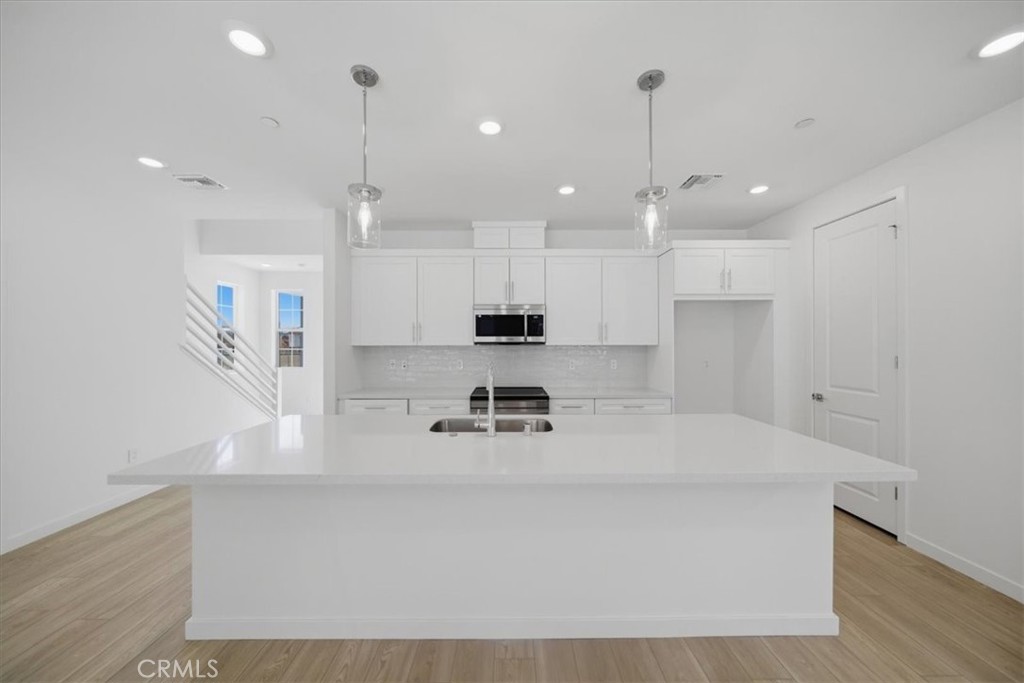 4801 Arroyo Run Moorpark, CA 93021 - Photo 9 of 27 a kitchen with kitchen island a counter top space appliances and a sink