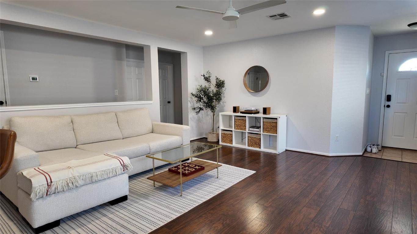a living room with furniture and a wooden floor