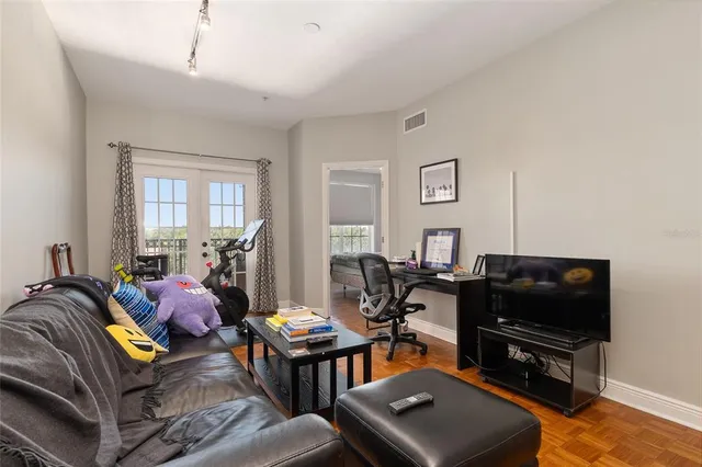 a living room with furniture a flat screen tv and a window