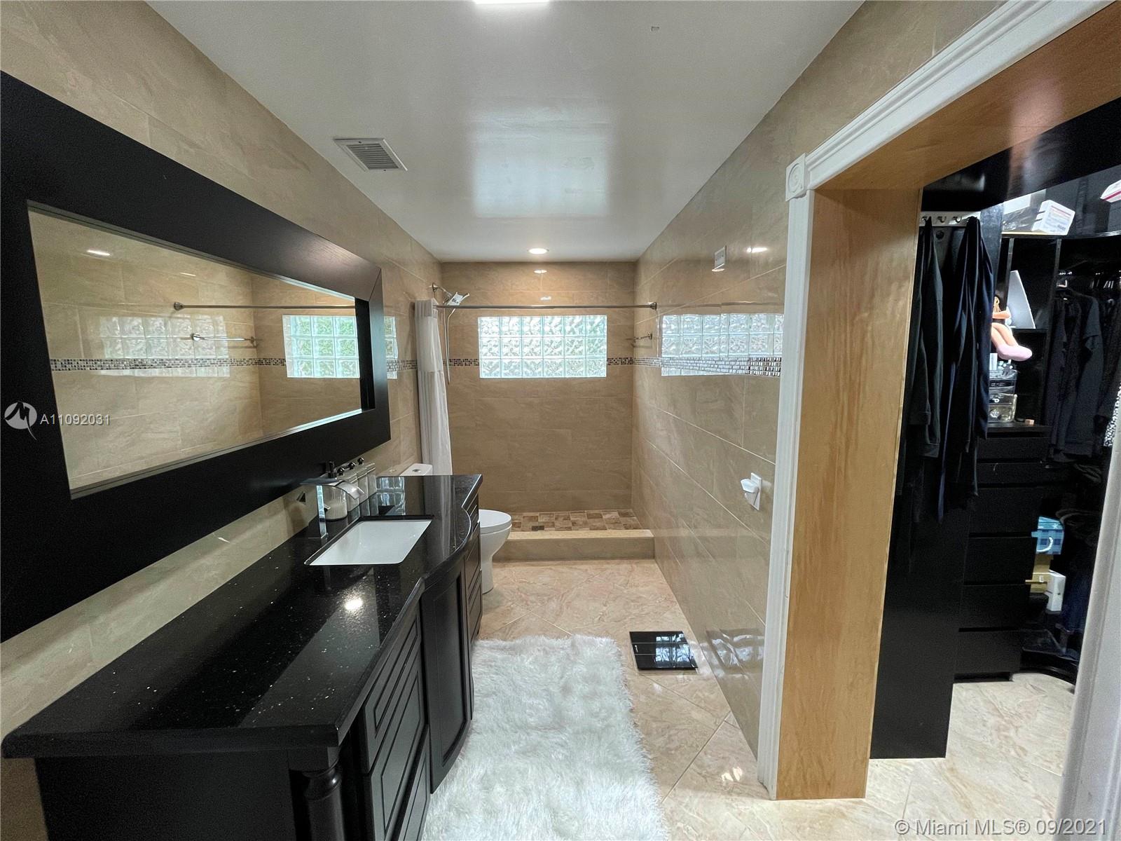 11114 Delta Circle Boca Raton, FL 33428 - Photo 5 of 15 a bathroom with a double vanity sink a toilet and a shower