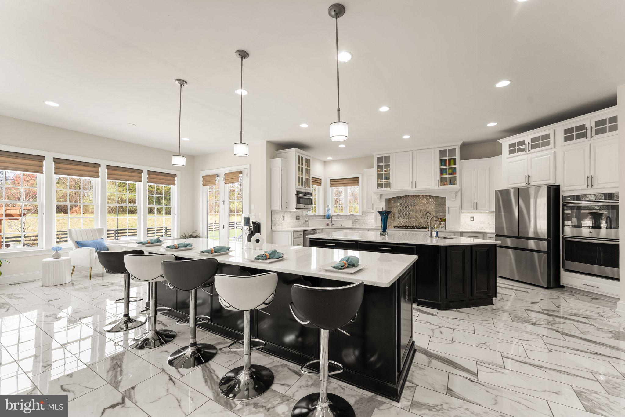 25873 Cameron Walk Place Aldie, VA 20105 - Photo 15 of 92 a kitchen with stainless steel appliances kitchen island granite countertop a sink a stove a refrigerator and chairs