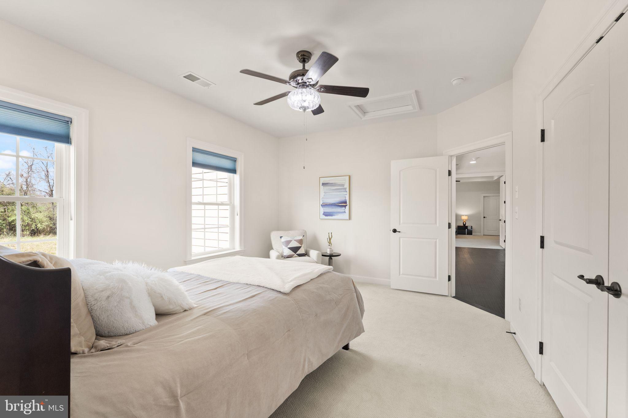 25873 Cameron Walk Place Aldie, VA 20105 - Photo 34 of 92 a spacious bedroom with a large bed and a chandelier