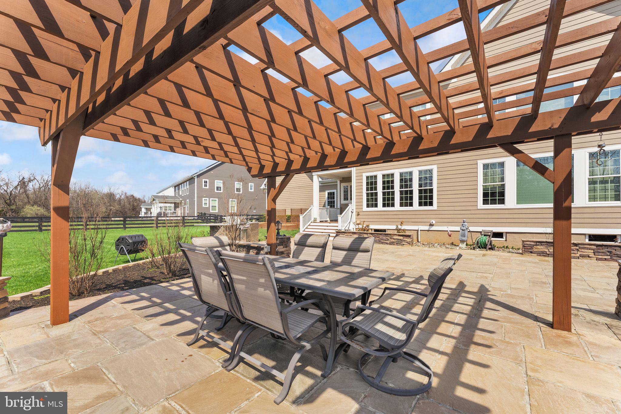 25873 Cameron Walk Place Aldie, VA 20105 - Photo 52 of 92 a view of a patio with table and chairs and floor to ceiling window with wooden fence