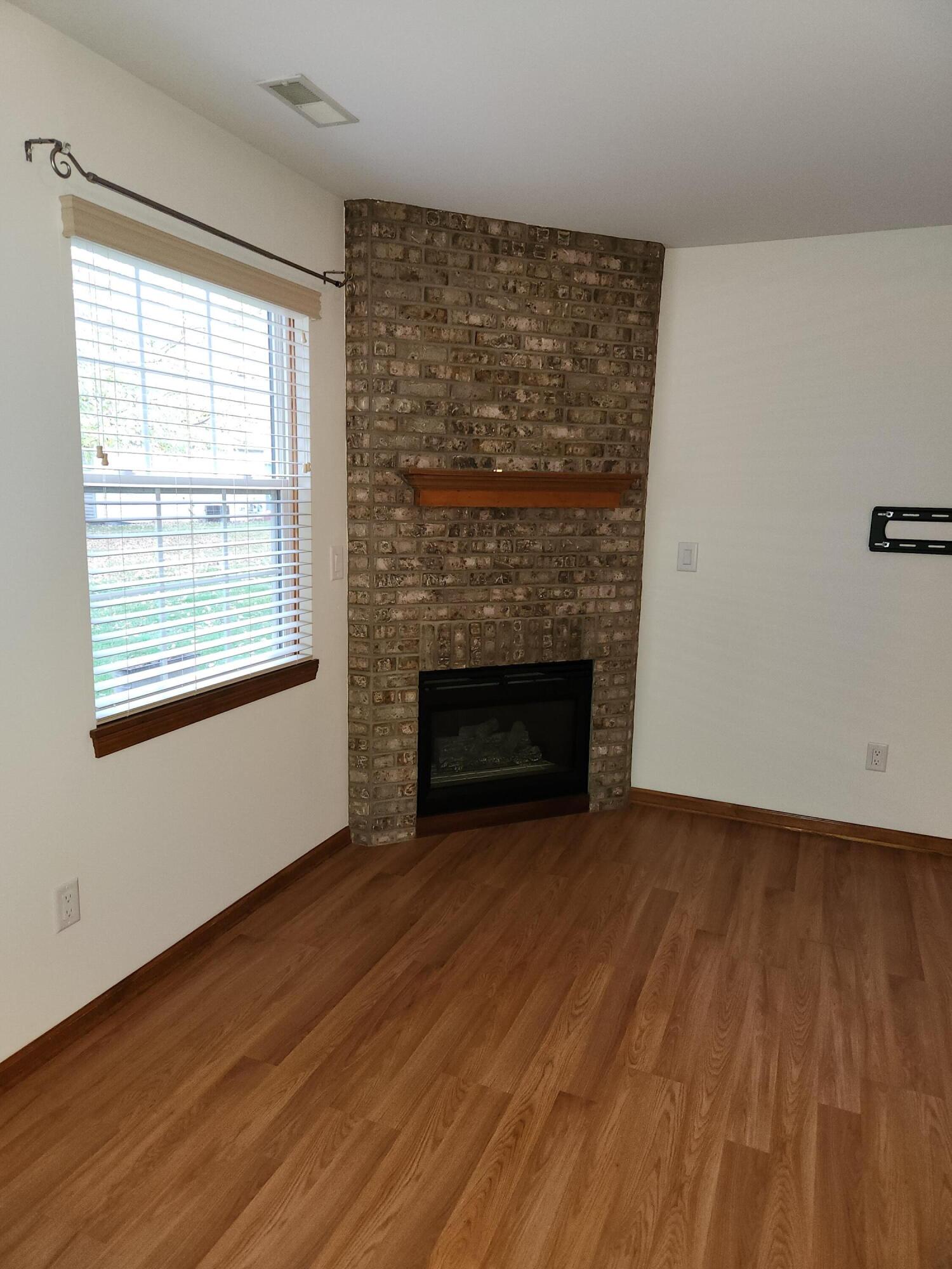 1920 David Drive Chesterton, IN 46304 - Photo 6 of 21 an empty room with wooden floor fireplace and windows