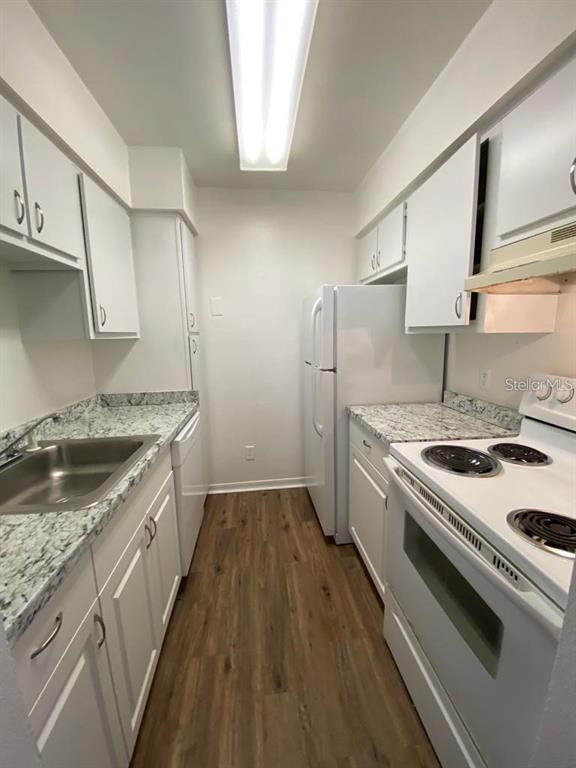 285 Wymore Road, Unit 101 Altamonte Springs, FL 32714 - Photo 4 of 9 a kitchen with granite countertop a sink stove and cabinets