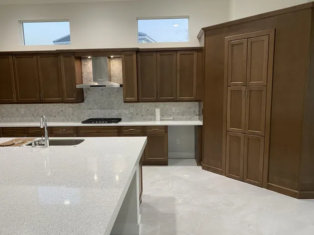 a kitchen with granite countertop a refrigerator and a sink