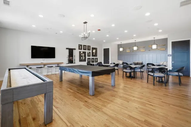 an aerial view of a tennis ground and a cars park side of the road