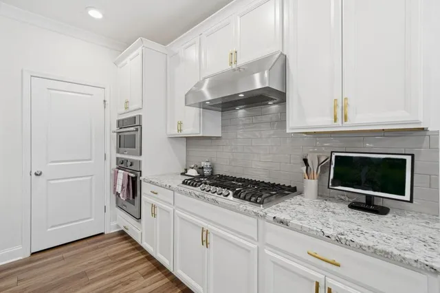 a kitchen with a refrigerator and a wooden floor