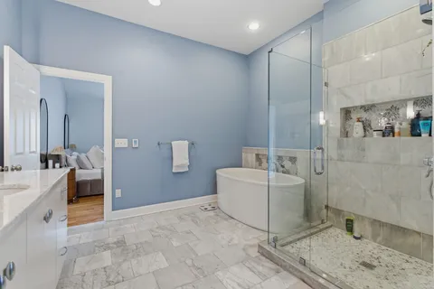 a bathroom with a tub a sink and mirror