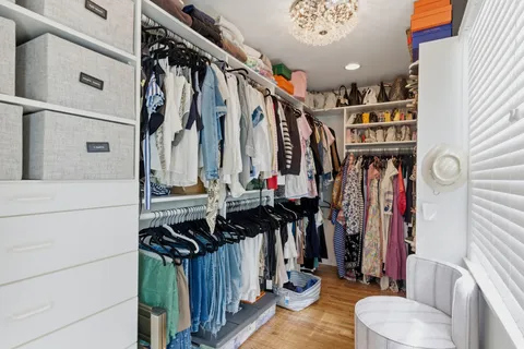 a view of walk in closet with clothes and shoes