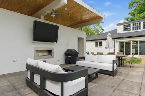 a living room with furniture a flat screen tv and a fireplace