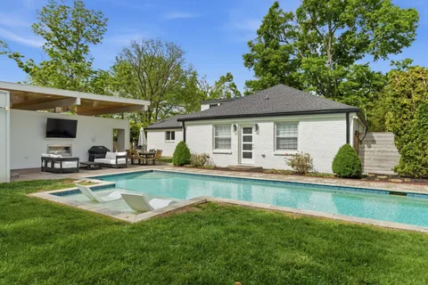 a view of a house with swimming pool and a yard