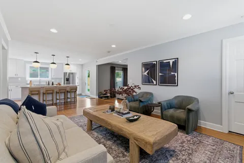 a living room with furniture a rug and a flat screen tv