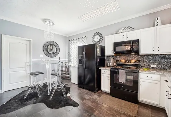 a kitchen with stainless steel appliances granite countertop a stove a refrigerator and a sink with wooden floor