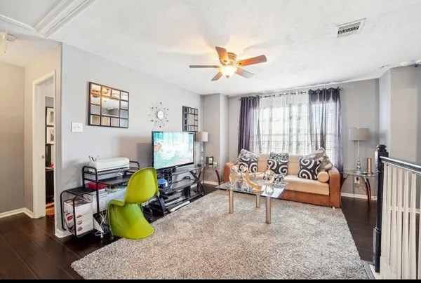 a living room with furniture and wooden floor