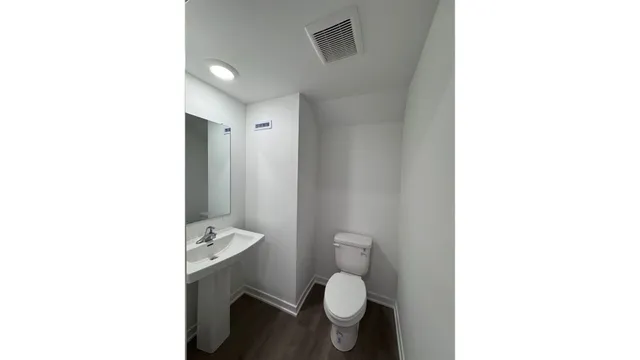a bathroom with a toilet a sink and a mirror