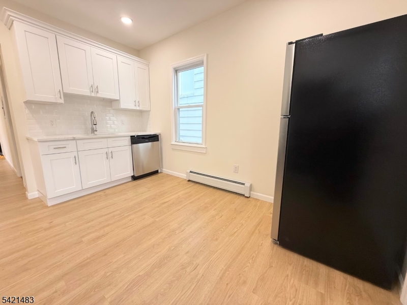356 Carnegie Place, Unit 1 Union, NJ 07088 - Photo 3 of 10 a kitchen with granite countertop white cabinets and black appliances