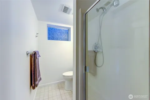 a bathroom with a shower a toilet and a shower