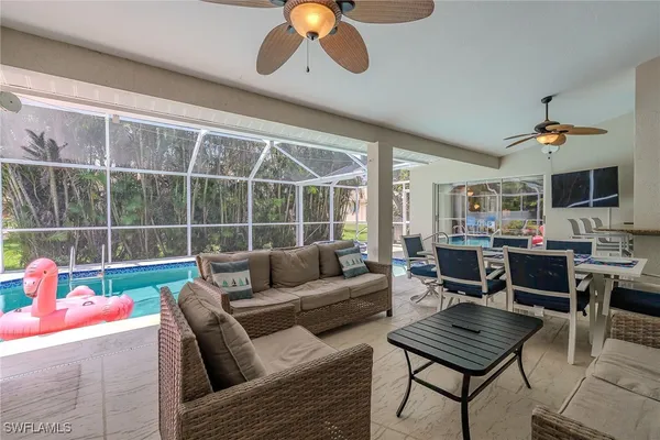 a living room with furniture a flat screen tv and a window