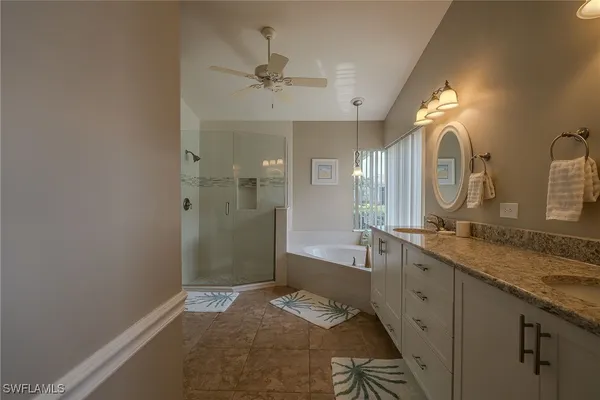 a spacious bathroom with a granite countertop sink a mirror and a shower