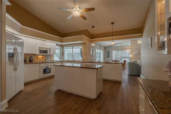 a kitchen with stainless steel appliances kitchen island granite countertop a stove a sink and a refrigerator