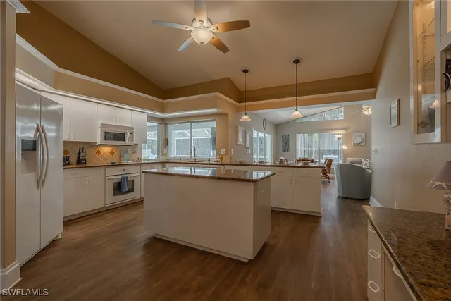 a kitchen with stainless steel appliances kitchen island granite countertop a stove a sink and a refrigerator
