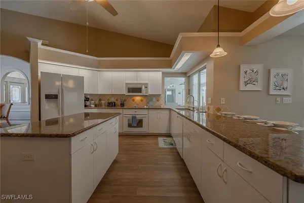 a large kitchen with stainless steel appliances granite countertop a sink and cabinets