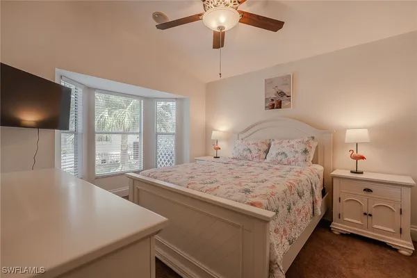 a bedroom with a bed and a flat tv screen on the dresser