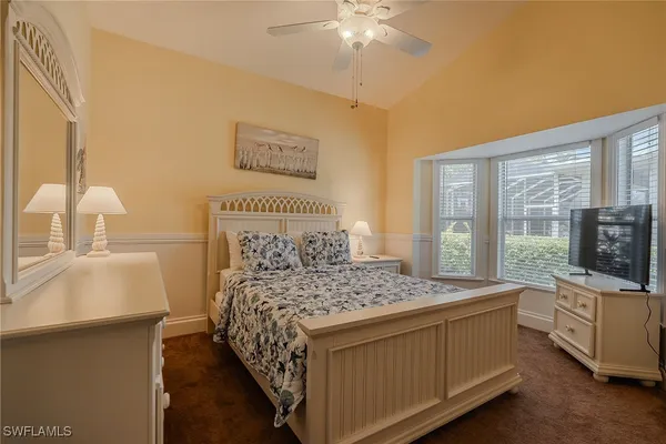 a bedroom with a bed and a flat tv screen on dresser