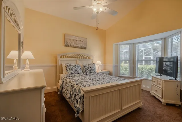 a bedroom with a bed and a flat tv screen on dresser