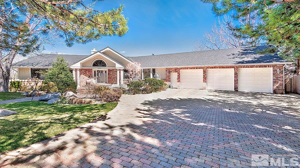 a front view of a house with a yard and trees