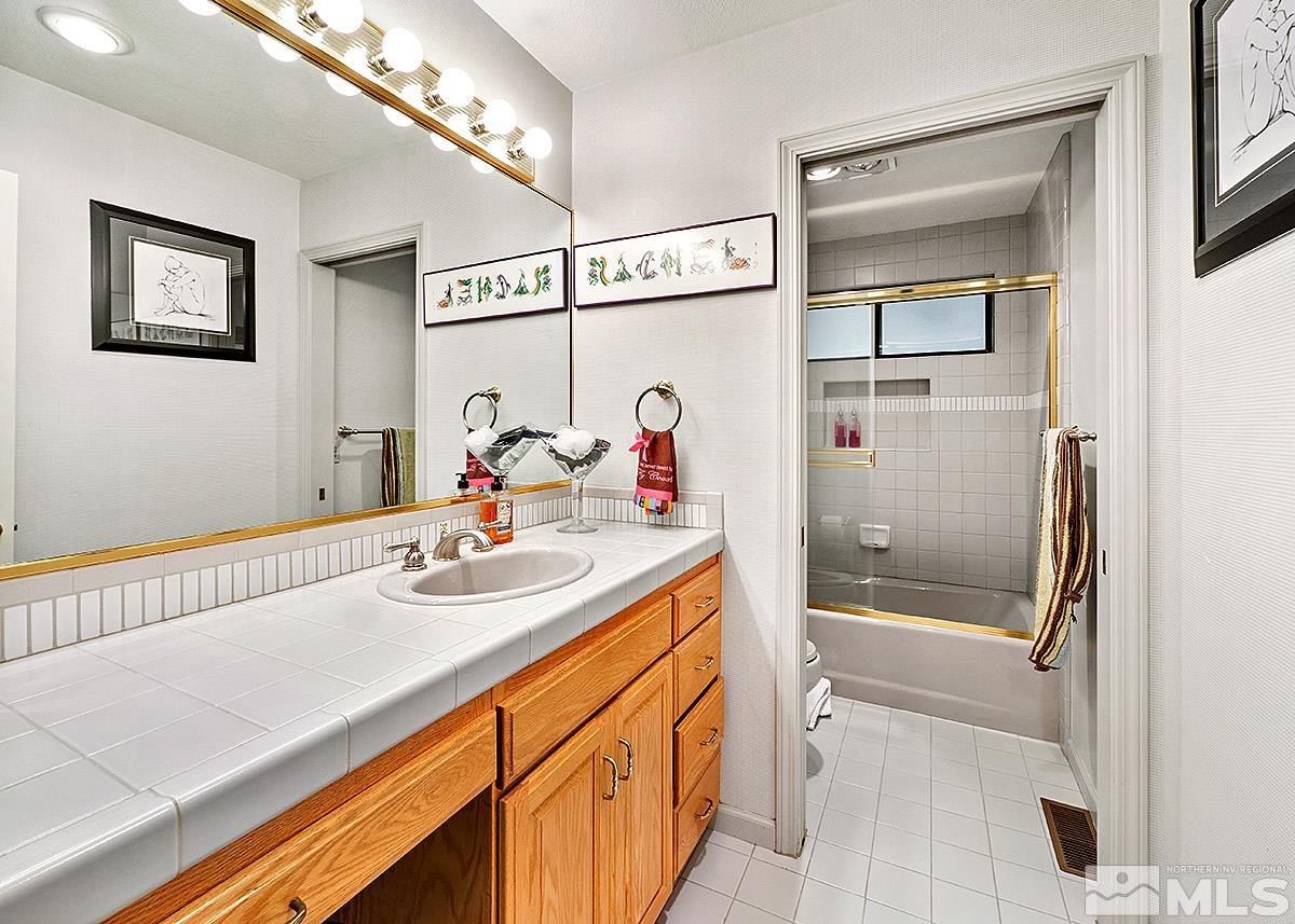 2215 Hedgewood Drive Reno, NV 89509 - Photo 31 of 39 a bathroom with a sink a toilet a mirror and shower