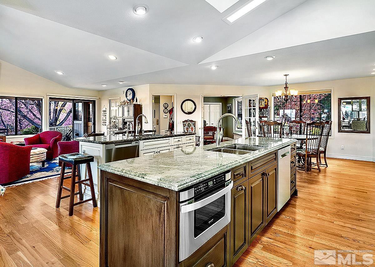 2215 Hedgewood Drive Reno, NV 89509 - Photo 9 of 39 a kitchen with stainless steel appliances granite countertop a kitchen island a sink dishwasher and a dining table with wooden floor
