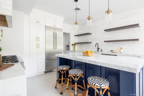 a kitchen with stainless steel appliances granite countertop a sink a stove and a refrigerator