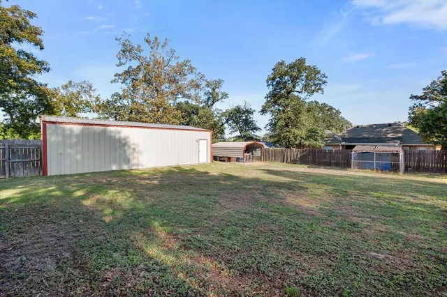a front view of house with yard and trees in the background