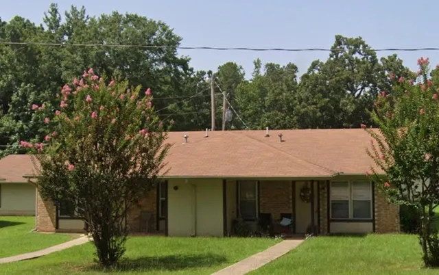 a view of a white house with a big yard and large tree