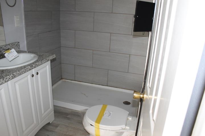875 Woodrow Street Silsbee, TX 77656 - Photo 19 of 30 a bathroom with a granite countertop bathtub sink and toilet