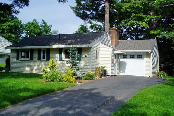 a front view of a house with a garden and plants